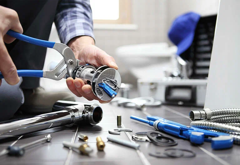 Technician repairing a plumbing fixture with professional tools in Bonita Springs