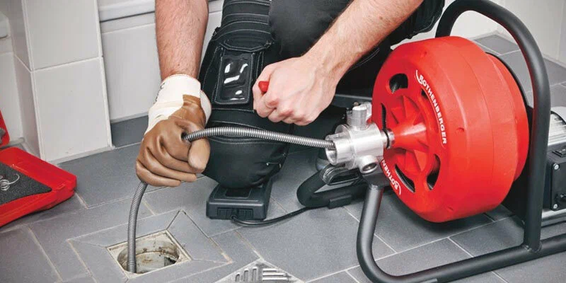 Plumber using a drain-cleaning machine in Bonita Springs