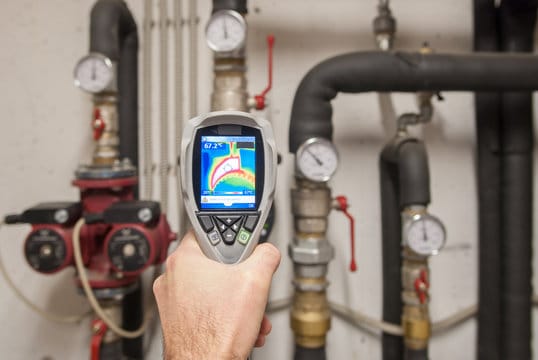 Plumber using a thermal imaging camera to inspect pipes in Bonita Springs