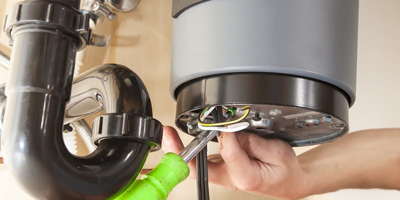 Technician repairing the heating element of a water heater in Bonita Springs