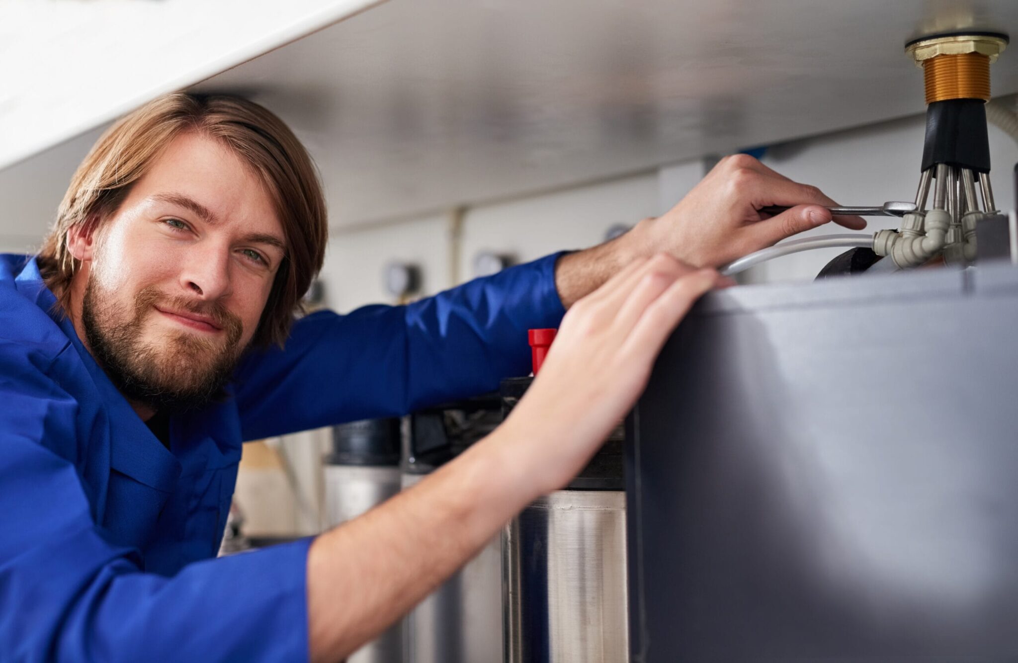 Technician servicing a residential water heater tank in Bonita Springs