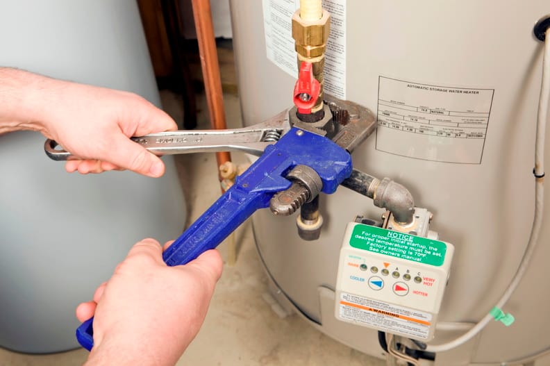 Plumber repairing a water heater valve in Bonita Springs